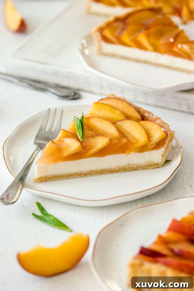 A slice of Panna Cotta Fresh Peach Tart on a white plate with gold rim, a fork resting on the side