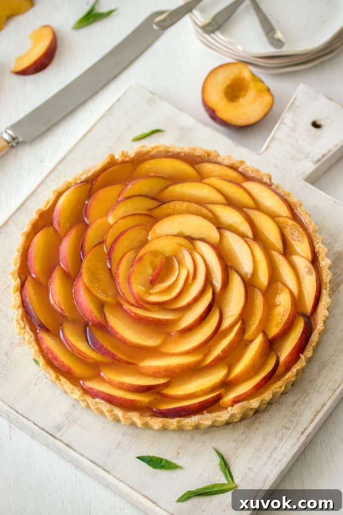 A whole tart decorated with fresh peach slices arranged in concentric circles