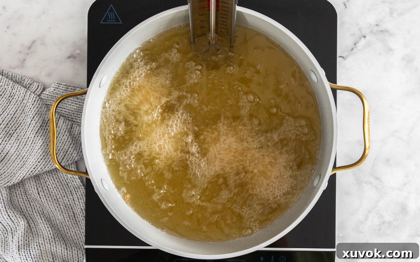 Chorizo arancini frying in hot deep oil.