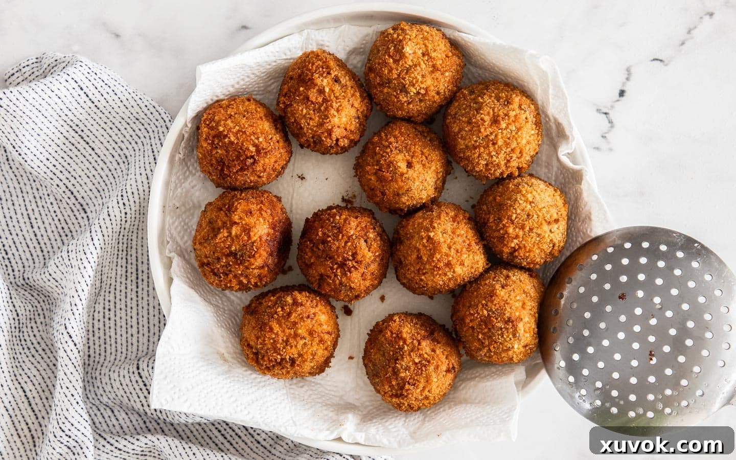 Plate of 12 golden-brown chorizo arancini ready to serve.