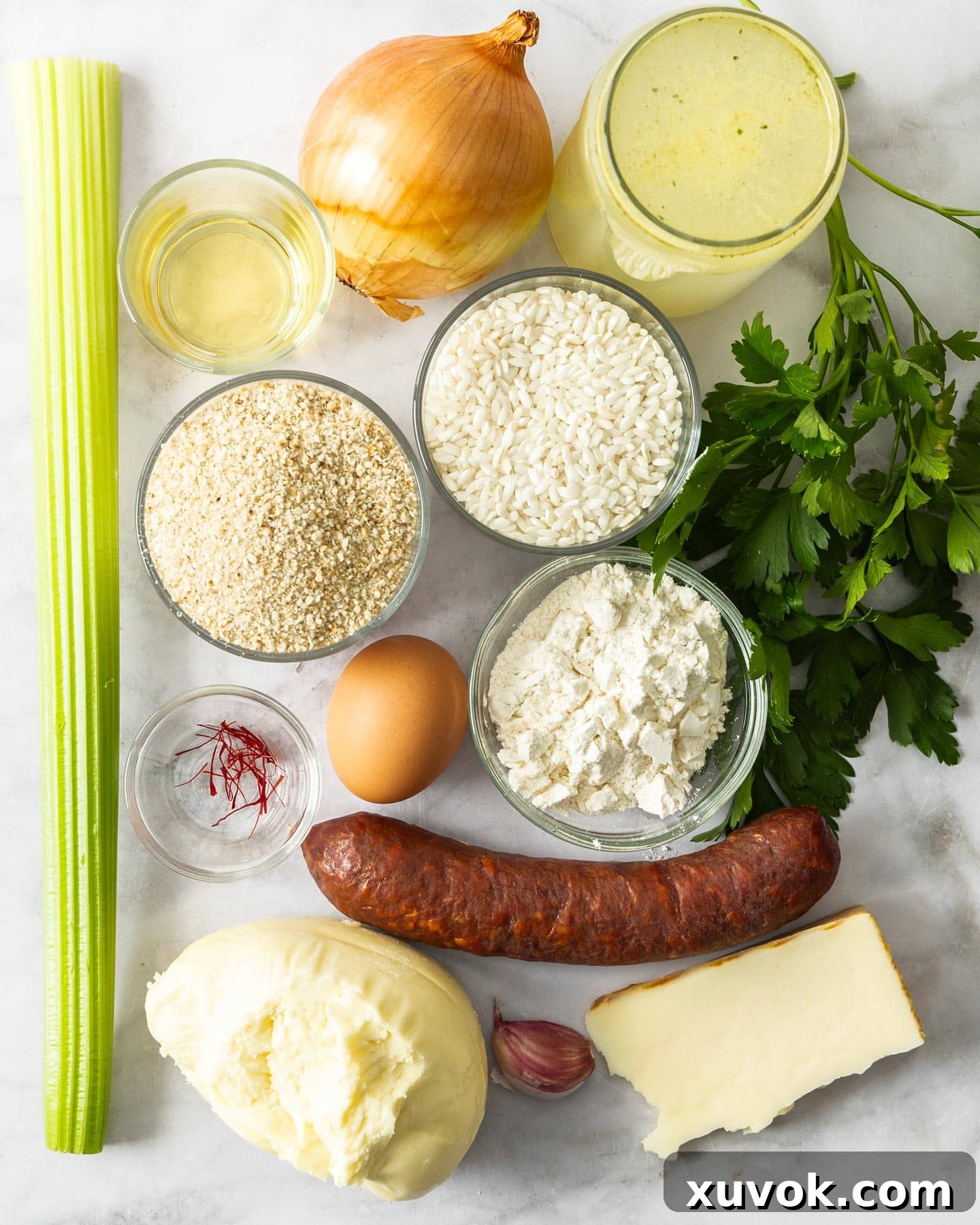 Ingredients for chorizo arancini on a marble surface.