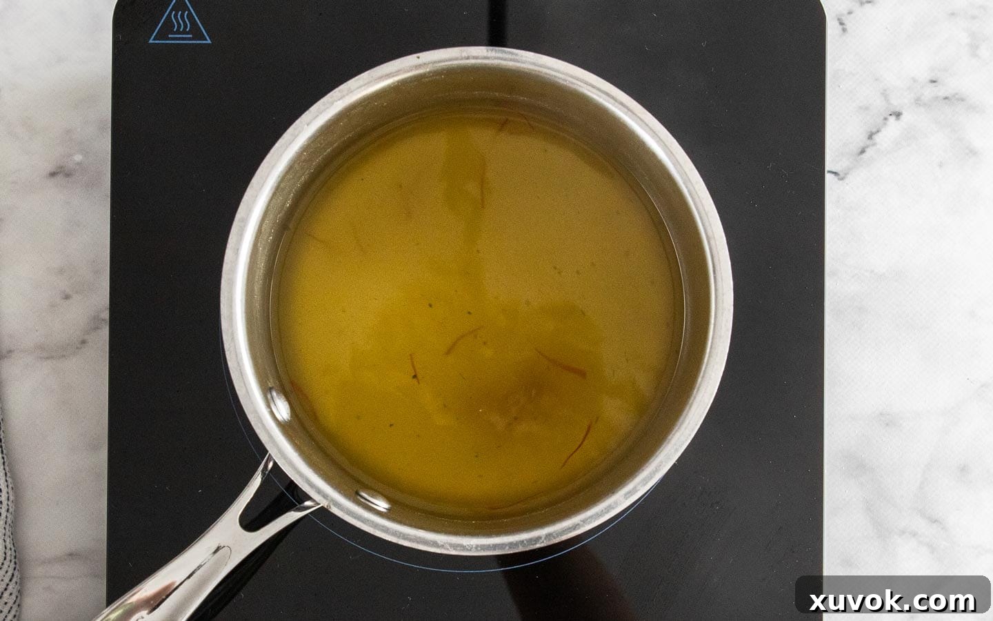 Saffron in stock infusing in a saucepan.