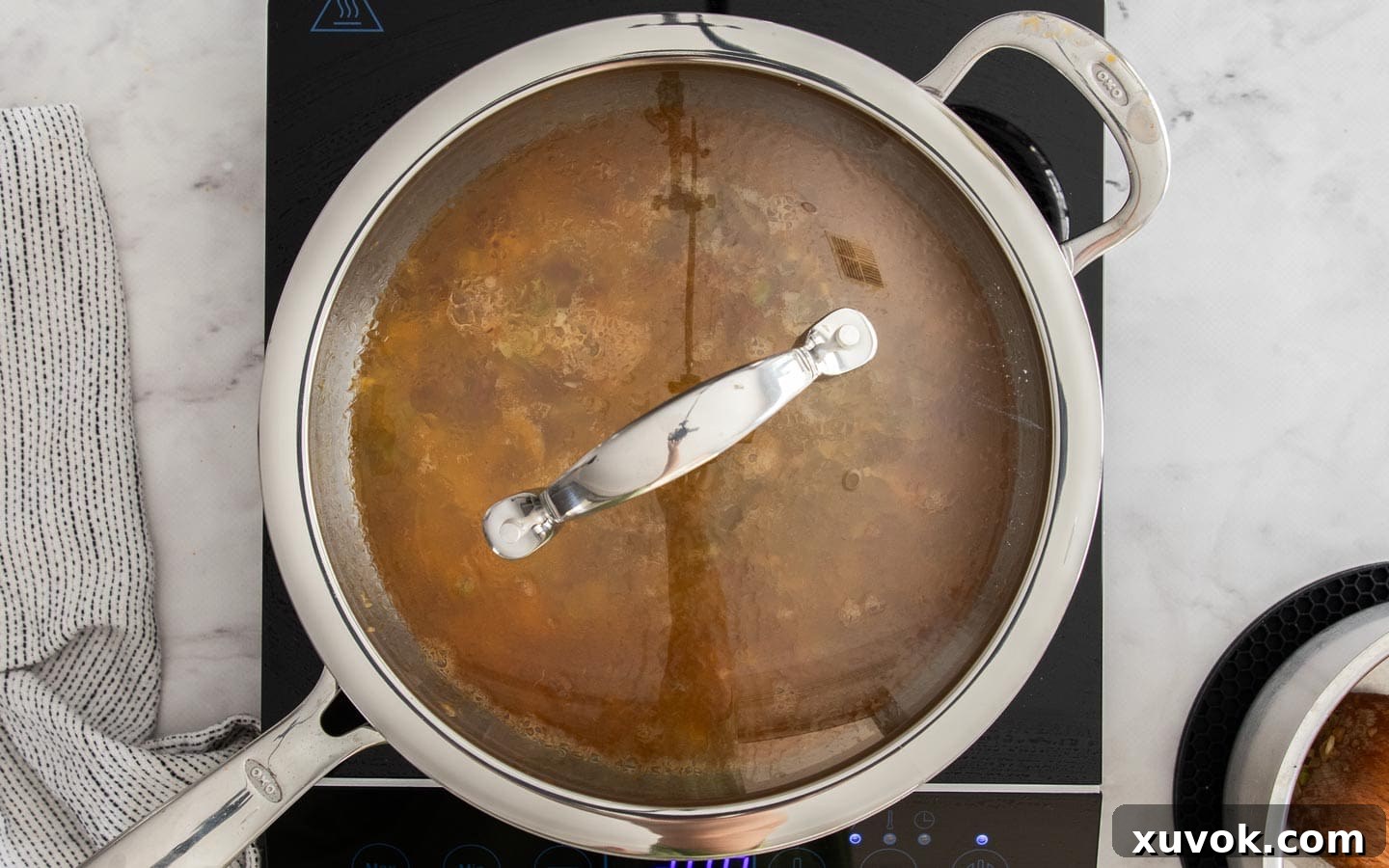 All remaining stock added to rice, covered with lid, for cooking.