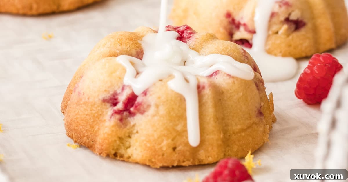 Closeup of a mini bundt cake being beautifully drizzled with white icing, highlighting its texture and delicate appearance.