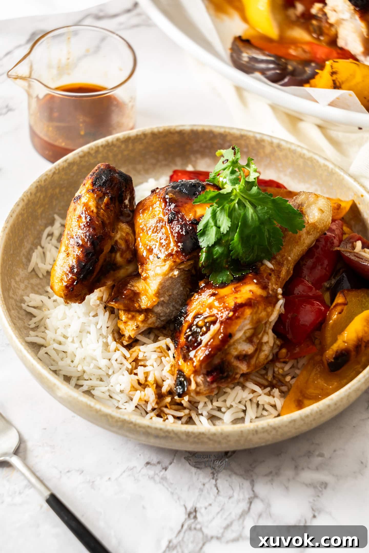 Harissa chicken served on a bed of rice in a rustic ceramic dish, garnished with fresh herbs.