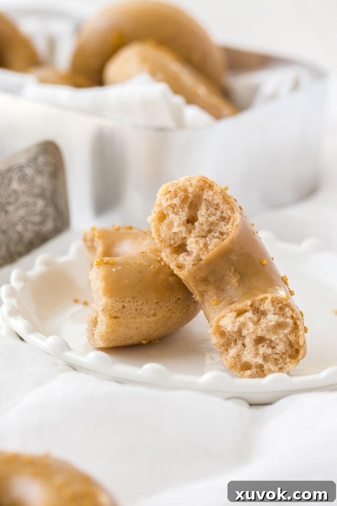 A broken open cake donut showing its soft, cake-like texture and a hint of cinnamon.