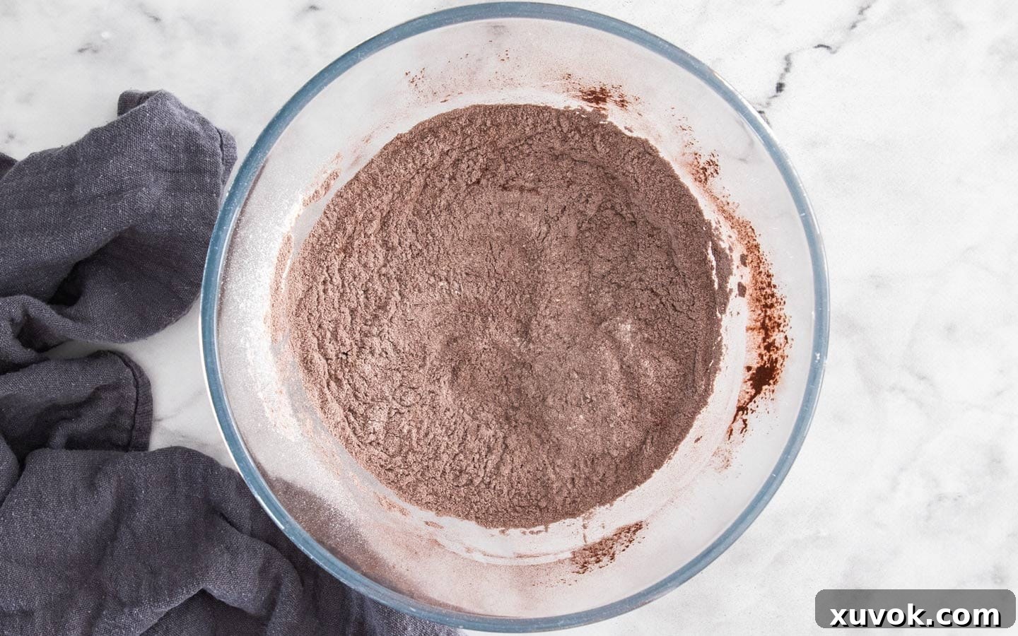Dry ingredients for chocolate cupcakes measured and mixed in a bowl.