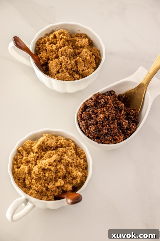 Three bowls showcasing different types of brown sugar: Dark Brown, Dark Muscovado, and Light Brown Sugar, highlighting their distinct colors and textures.