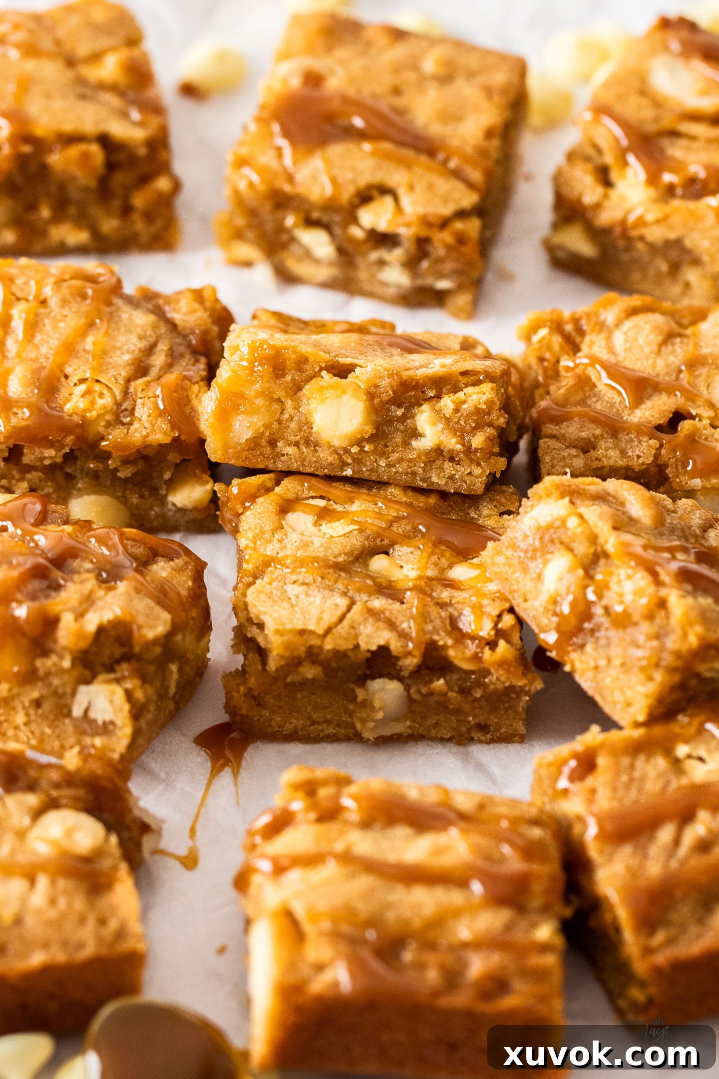 A tantalizing pile of golden caramel blondies, generously drizzled with extra caramel sauce, inviting you to indulge.