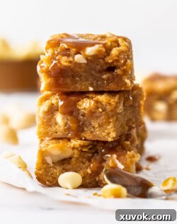 A stack of three golden caramel blondies, showcasing their rich color and inviting texture.