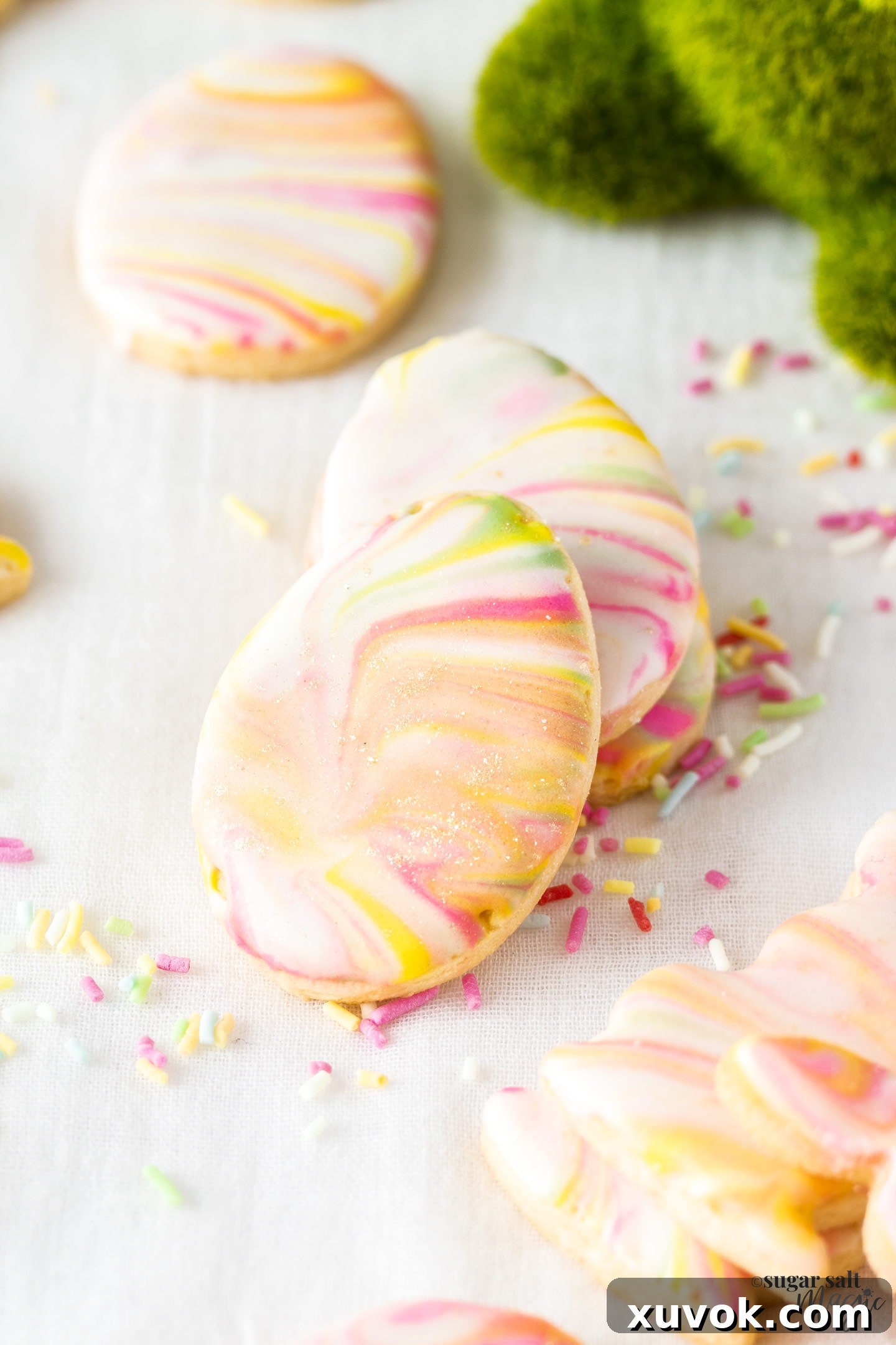 A small stack of marbled iced sugar cookies with soft pastel colors.