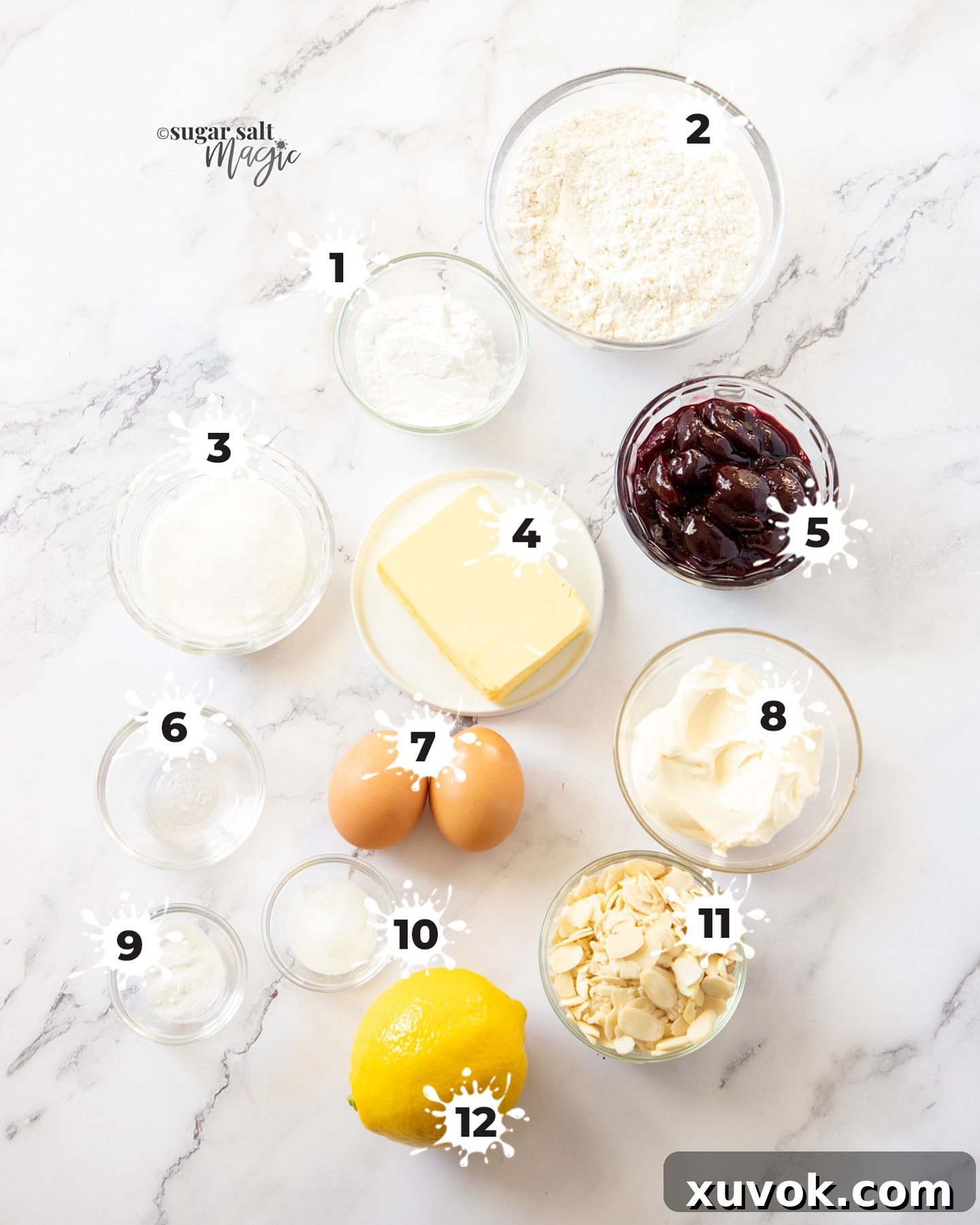 A curated selection of fresh ingredients laid out on a marble surface, ready for making the cherry cake.