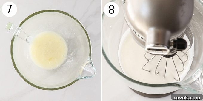 A stand mixer vigorously whipping the meringue mixture to stiff, glossy peaks, creating a light and airy topping for the lemon meringue cheesecake.