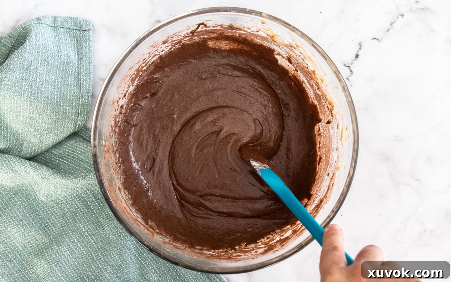 The rich, glossy brownie batter, perfectly mixed and ready to be poured into the pie shell.