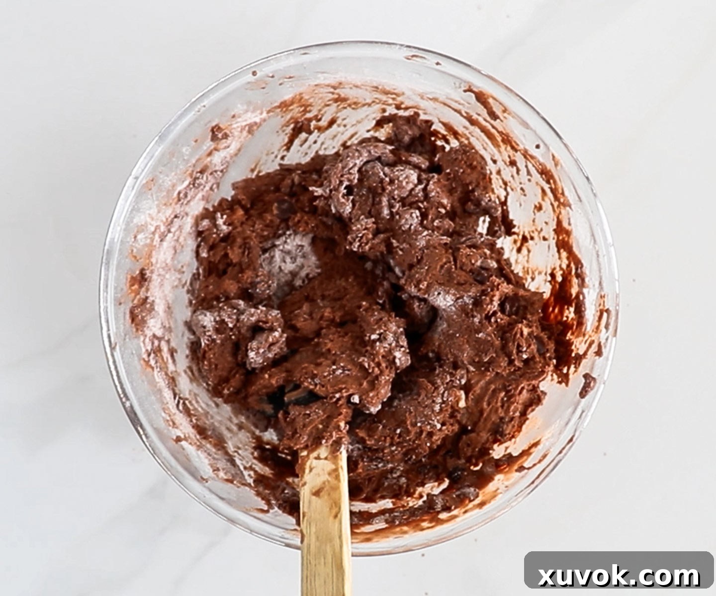 Sticky chocolate scone dough with chocolate chips in a mixing bowl, ready for shaping.