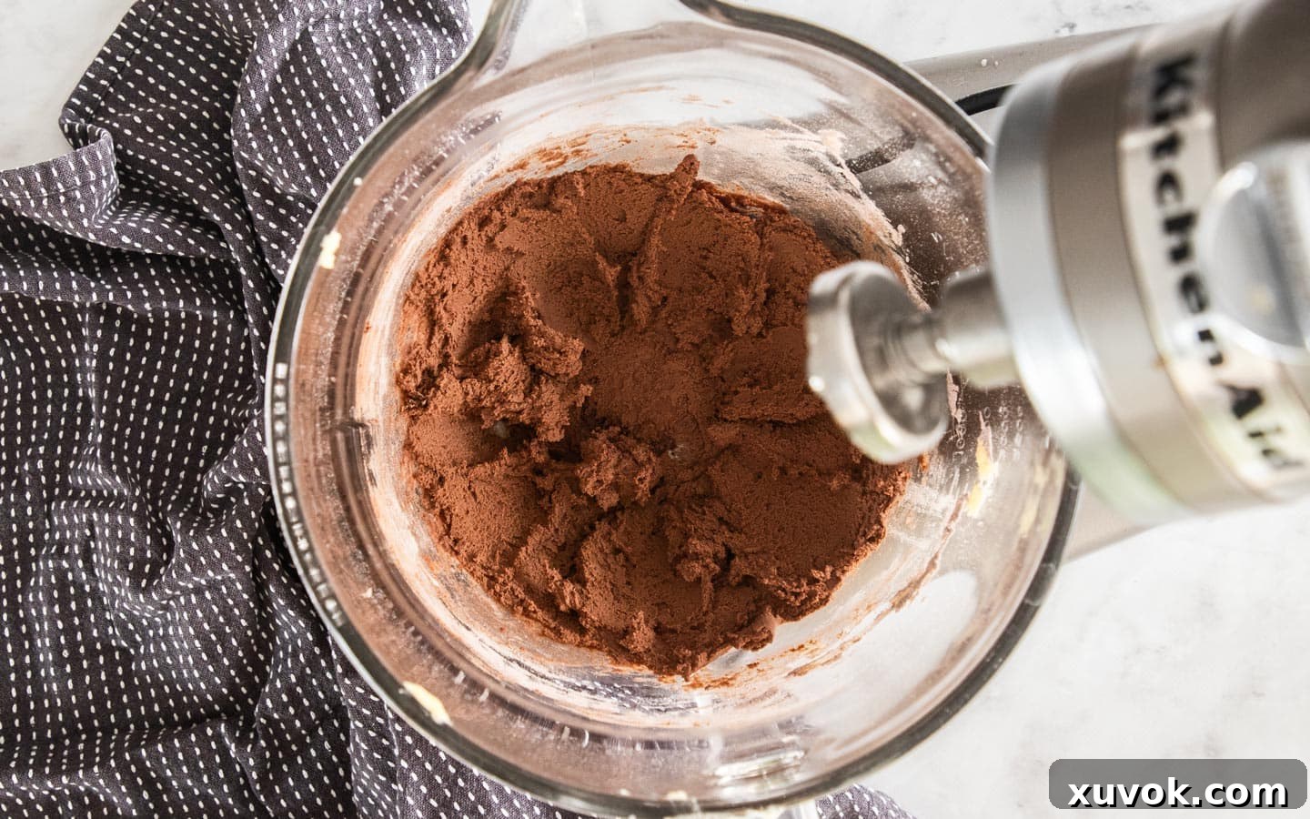 A rich, dark chocolate cookie dough, beautifully combined and ready for shaping, resting in a large mixing bowl.
