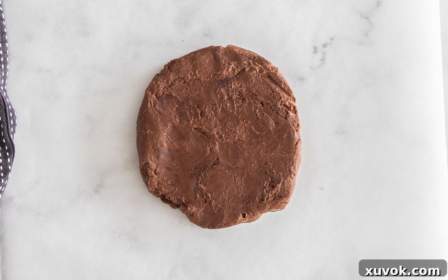 The dark chocolate shortbread dough expertly shaped into a smooth, even disk, ready for its crucial chilling period.