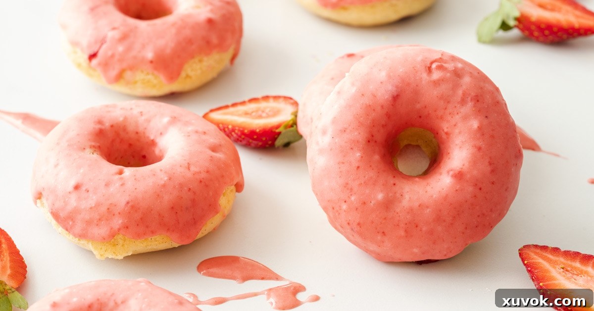 Two perfectly glazed Baked Strawberry Doughnuts, ready to enjoy