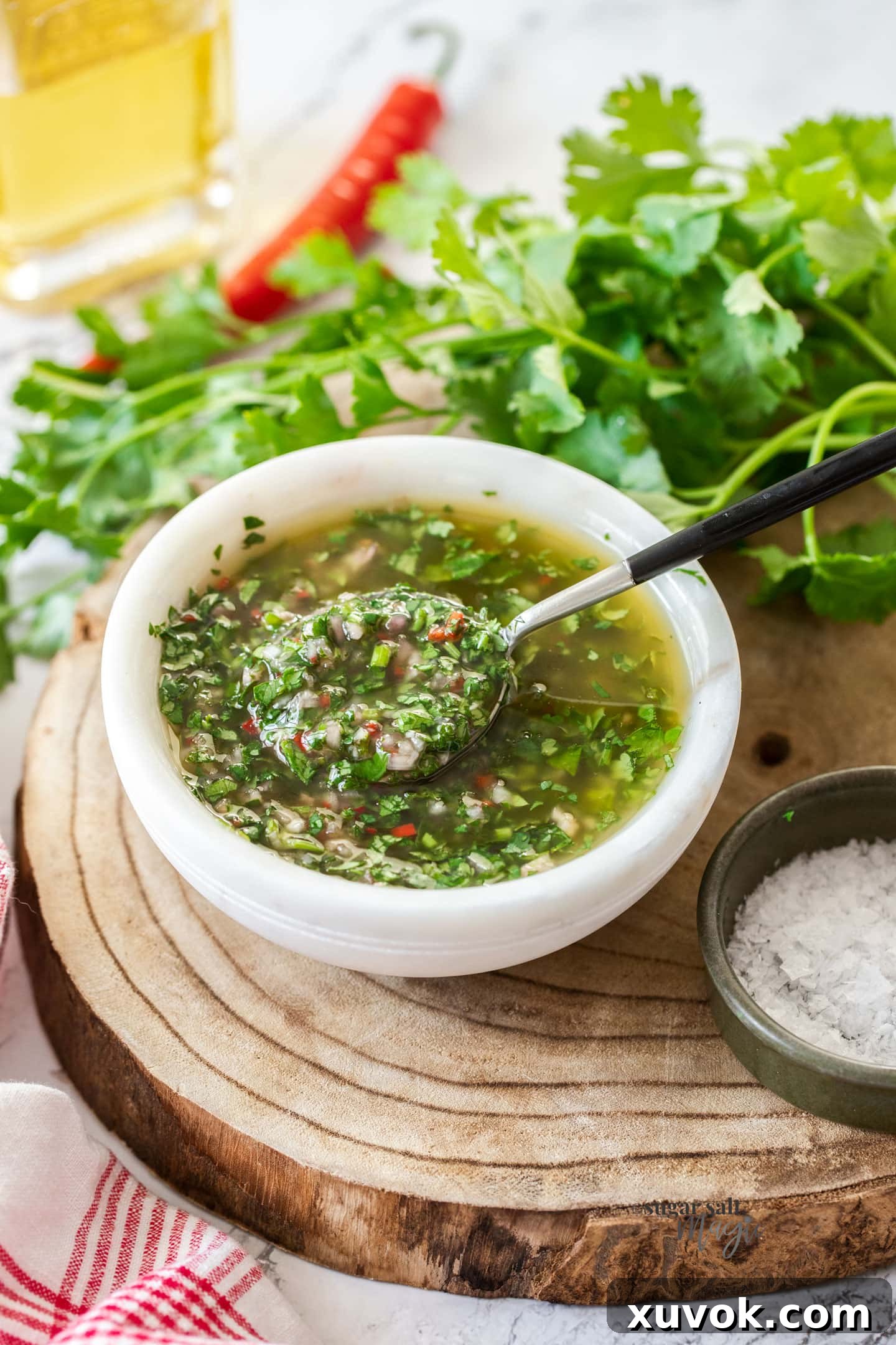 A bowl filled with herb sauce with a spoon dipping in.