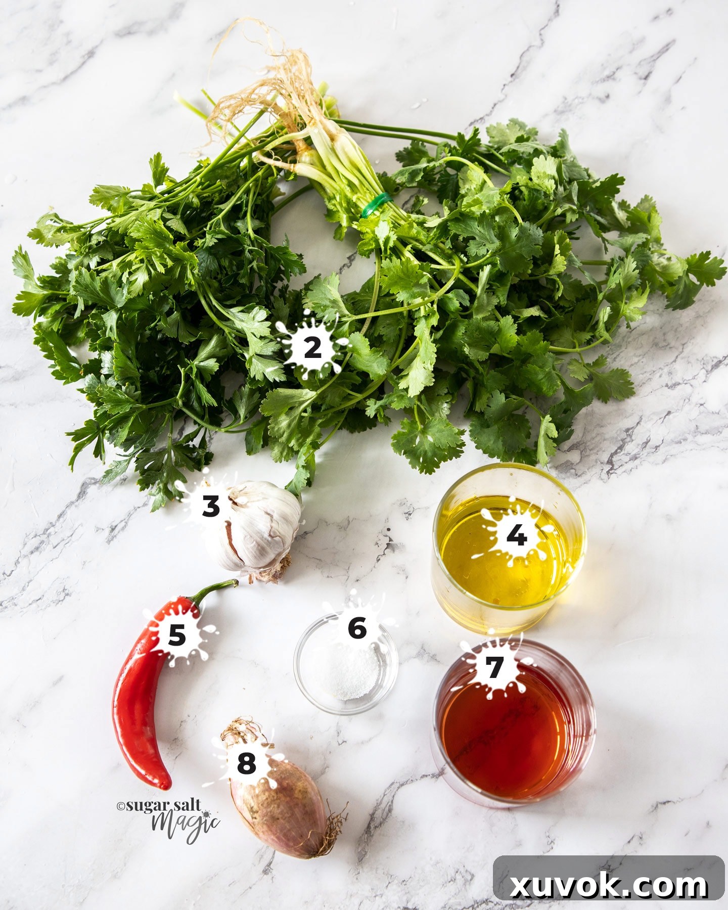 Ingredients for chimichurri sauce on a marble background.