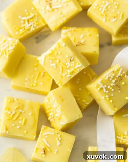 Squares of bright yellow lemon fudge on a marble platter, ready to be served.