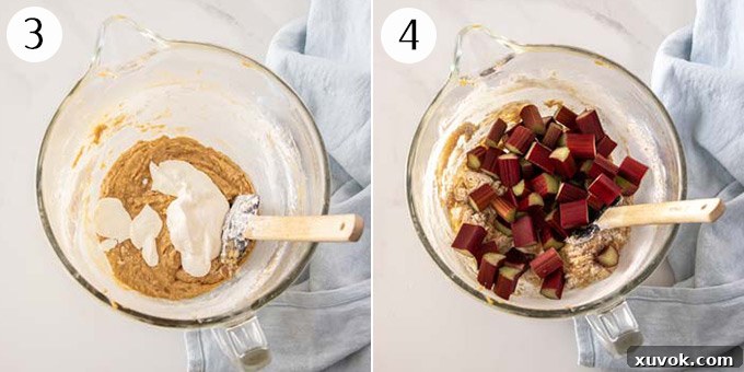 The image captures sour cream and fresh rhubarb pieces being gently folded into the cake batter within a clear glass bowl, showcasing the vibrant colors and rich texture before baking.