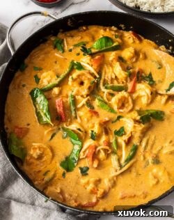 A black skillet filled with prawn curry.