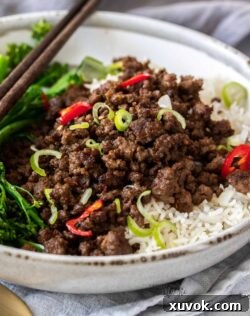 Closeup of a grey bowl filled with rice and crispy stir fried beef mince.