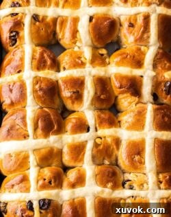 Top down view of a batch of 12 just-baked hot cross buns.