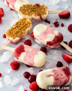 6 Strawberry Cheesecake Ice Cream Bars on a concrete background surrounded by ice and berries