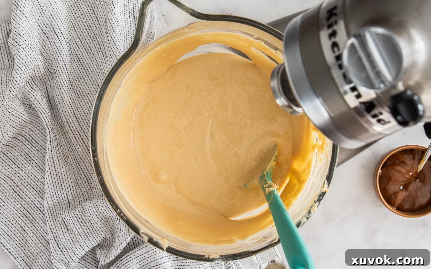 The completed cheesecake filling, a rich, smooth batter, resting in a large mixing bowl, ready to be poured into the crust.