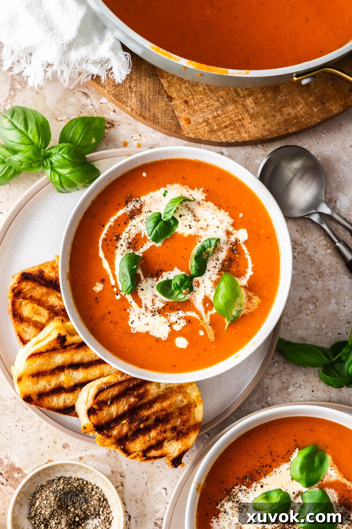 A top-down view of a garnished bowl of roasted garlic tomato soup, ready to be enjoyed.
