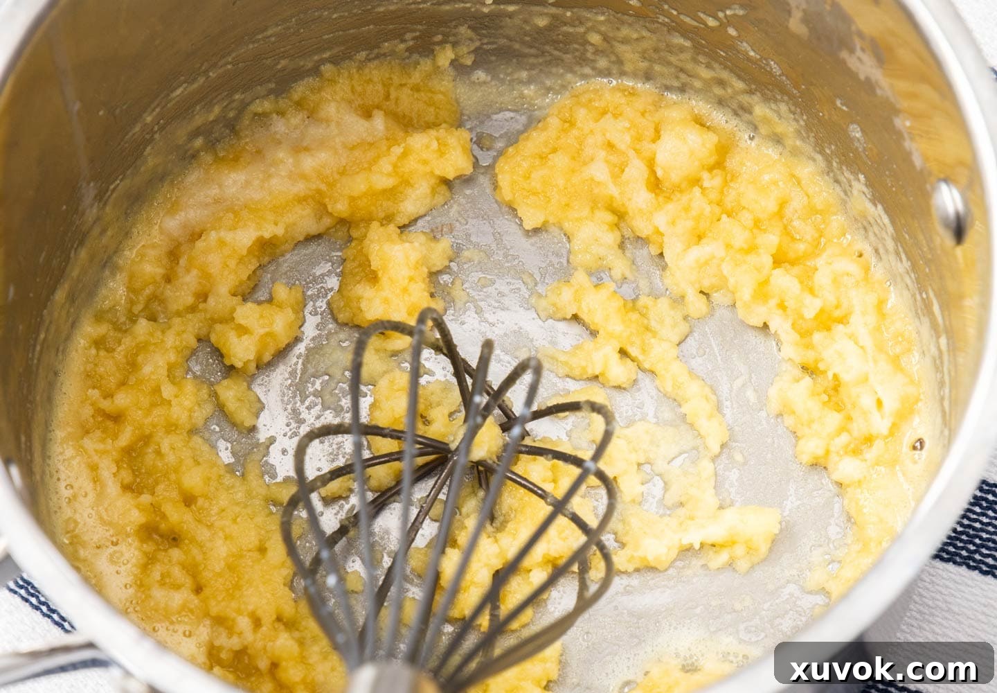 The béchamel sauce looking slightly lumpy before all the milk has been fully incorporated and whisked smooth.