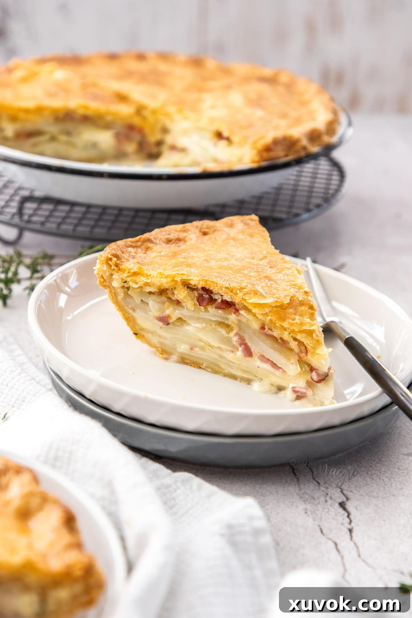 A slice of potato filled pie on a white plate.
