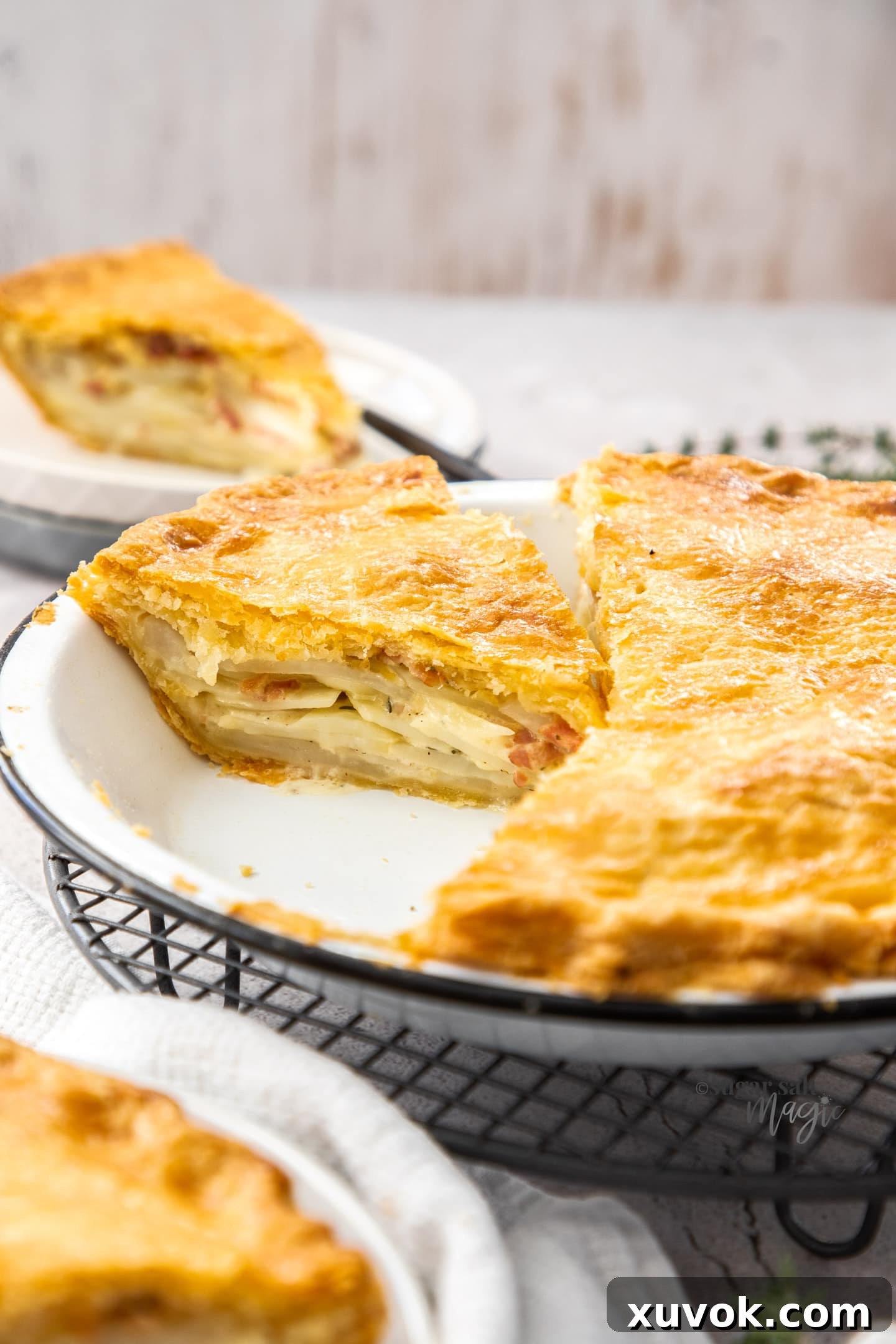 A potato pie in a pie tin with slices cut from it.