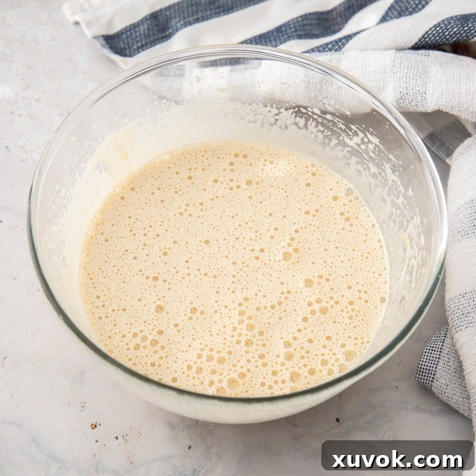 Frothy beaten eggs and sugar in a glass bowl