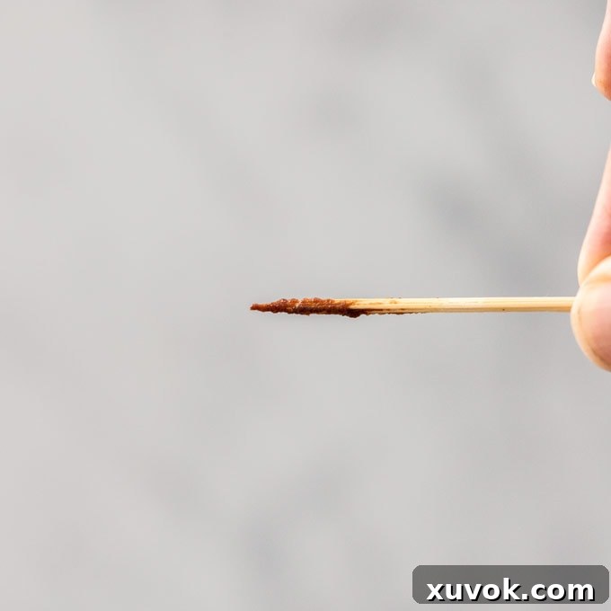 A toothpick with lots of brownie batter sticking to it