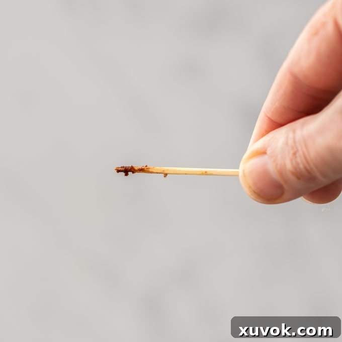 A toothpick with some brownie batter sticking on it