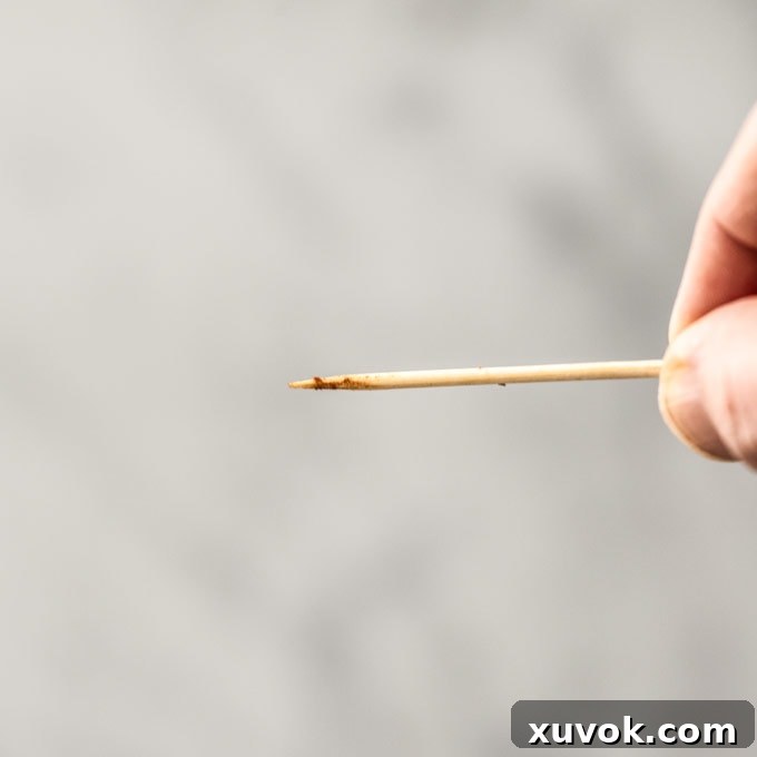 A toothpick with barely any brownie batter sticking on it
