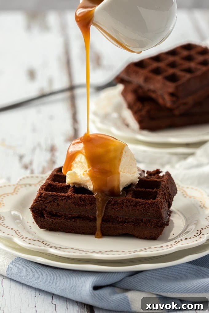 A perfectly cooked waffle brownie adorned with a scoop of vanilla ice cream, generously drizzled with rich caramel sauce. A truly indulgent dessert experience.