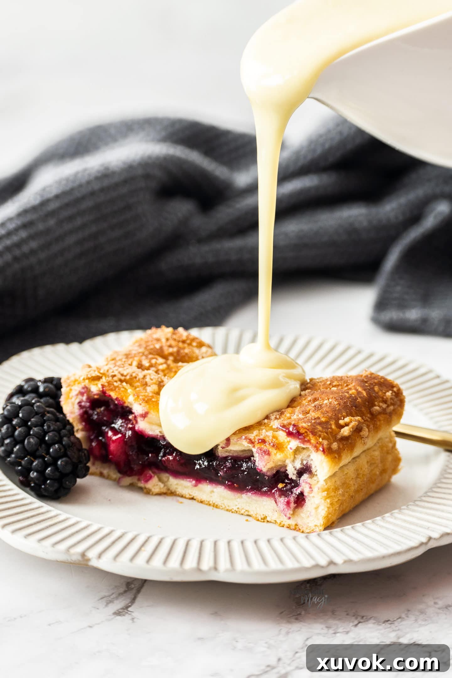 Warm, creamy custard being generously poured over a delicious Danish pastry, illustrating a perfect serving suggestion.