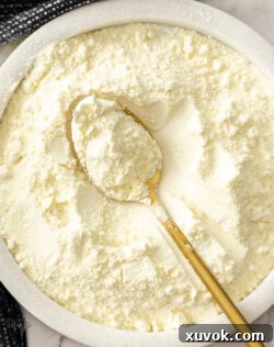 A spoon resting in a bowl of homemade custard powder, ready for use.