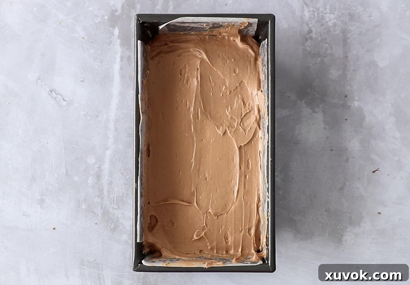 The chocolate cheesecake base in a loaf pan.