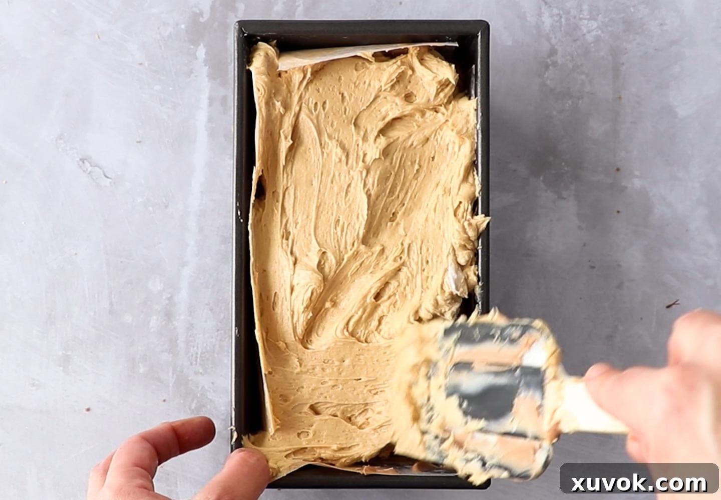 Spreading the peanut butter cheesecake over the chocolate base.