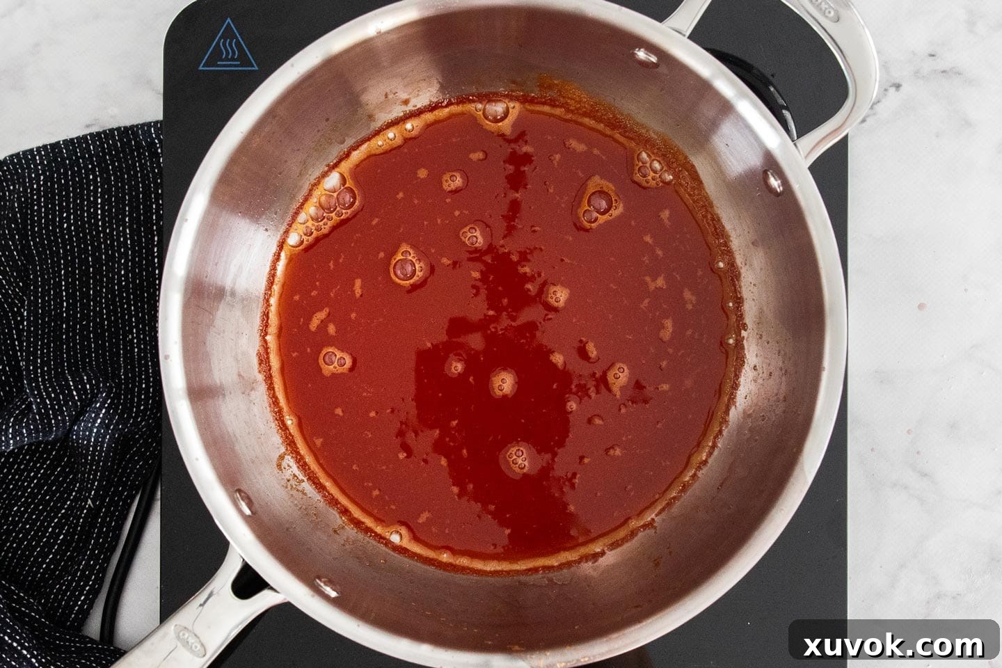 Reduced blood orange juice, now concentrated and darker, ready for the next step in the saucepan.