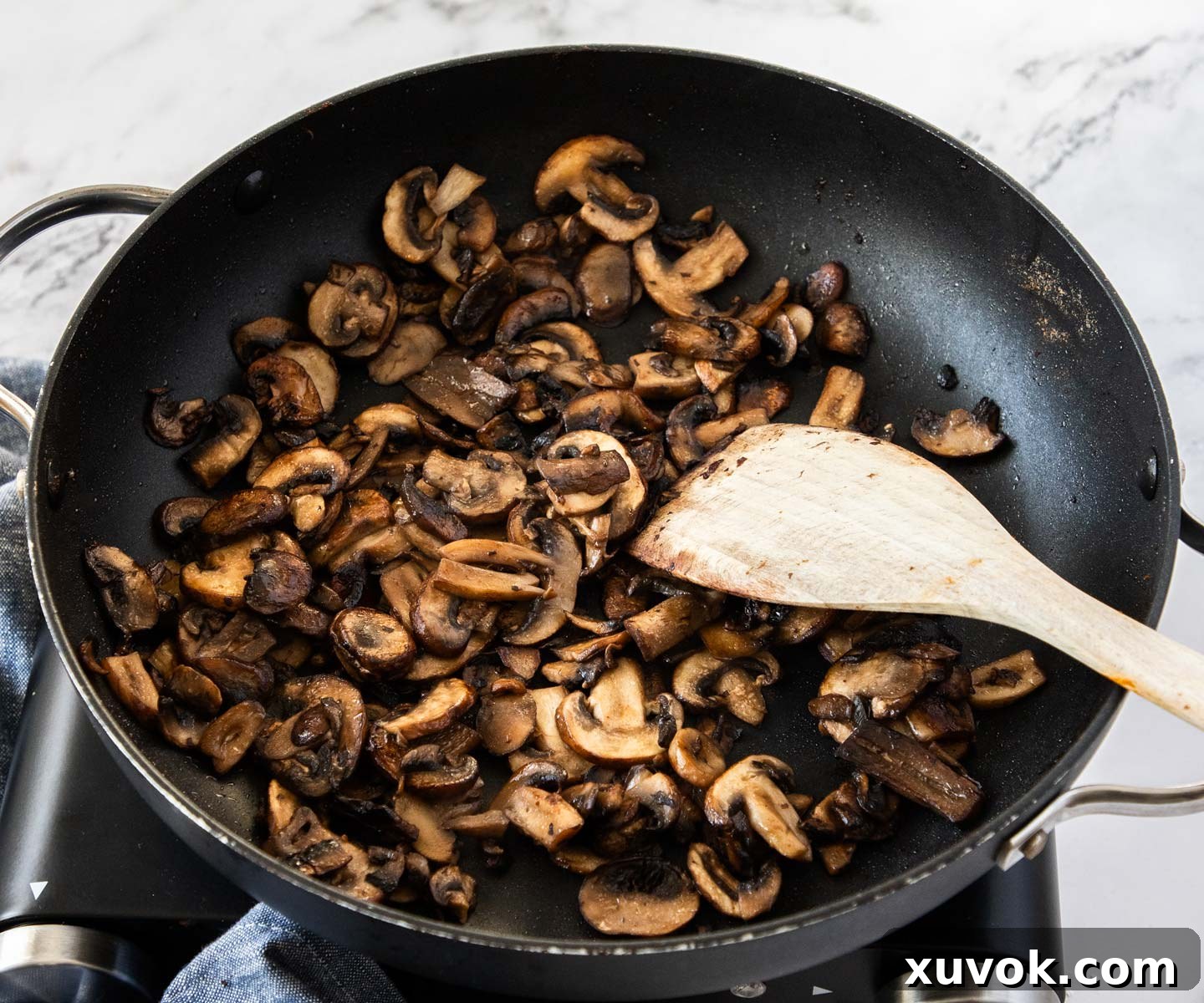 Cooking the mushrooms in a pan until golden brown and tender.