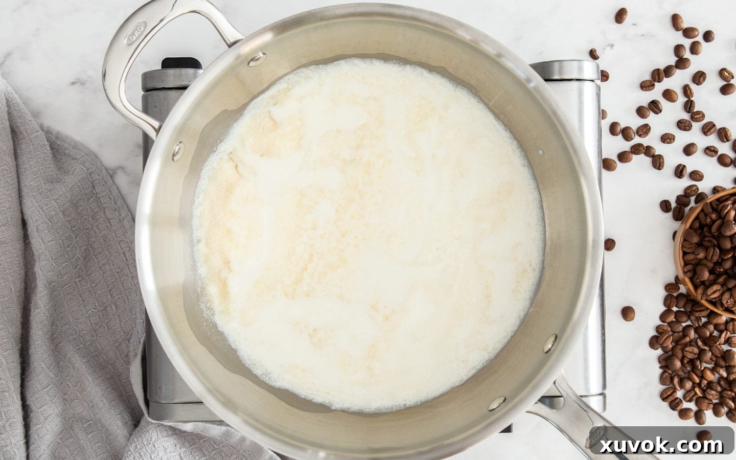 A close-up of bloomed gelatin on milk, showing its wrinkled, softened appearance after 5 minutes.