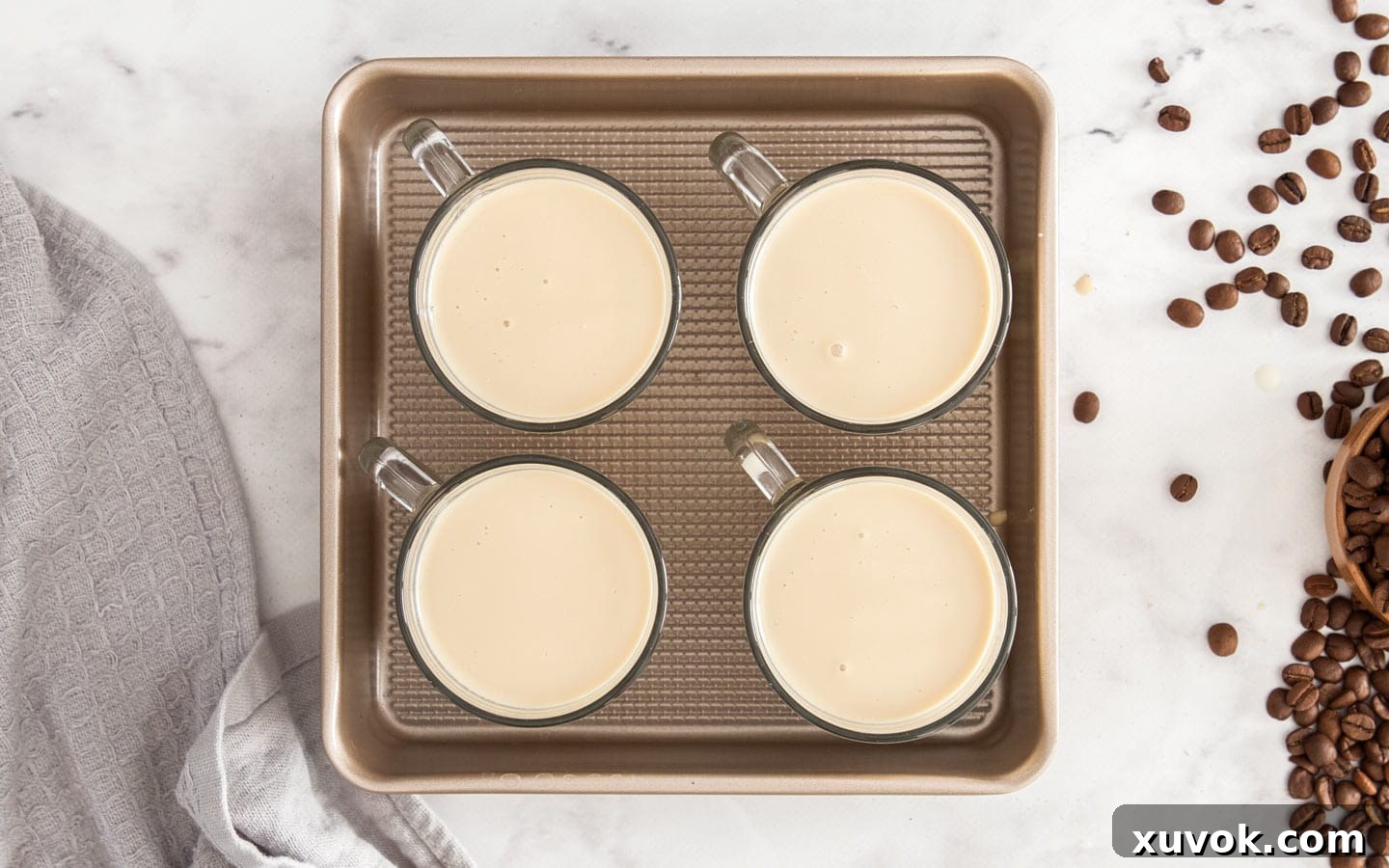 The coffee panna cotta mixture portioned into four elegant serving cups, ready for chilling.