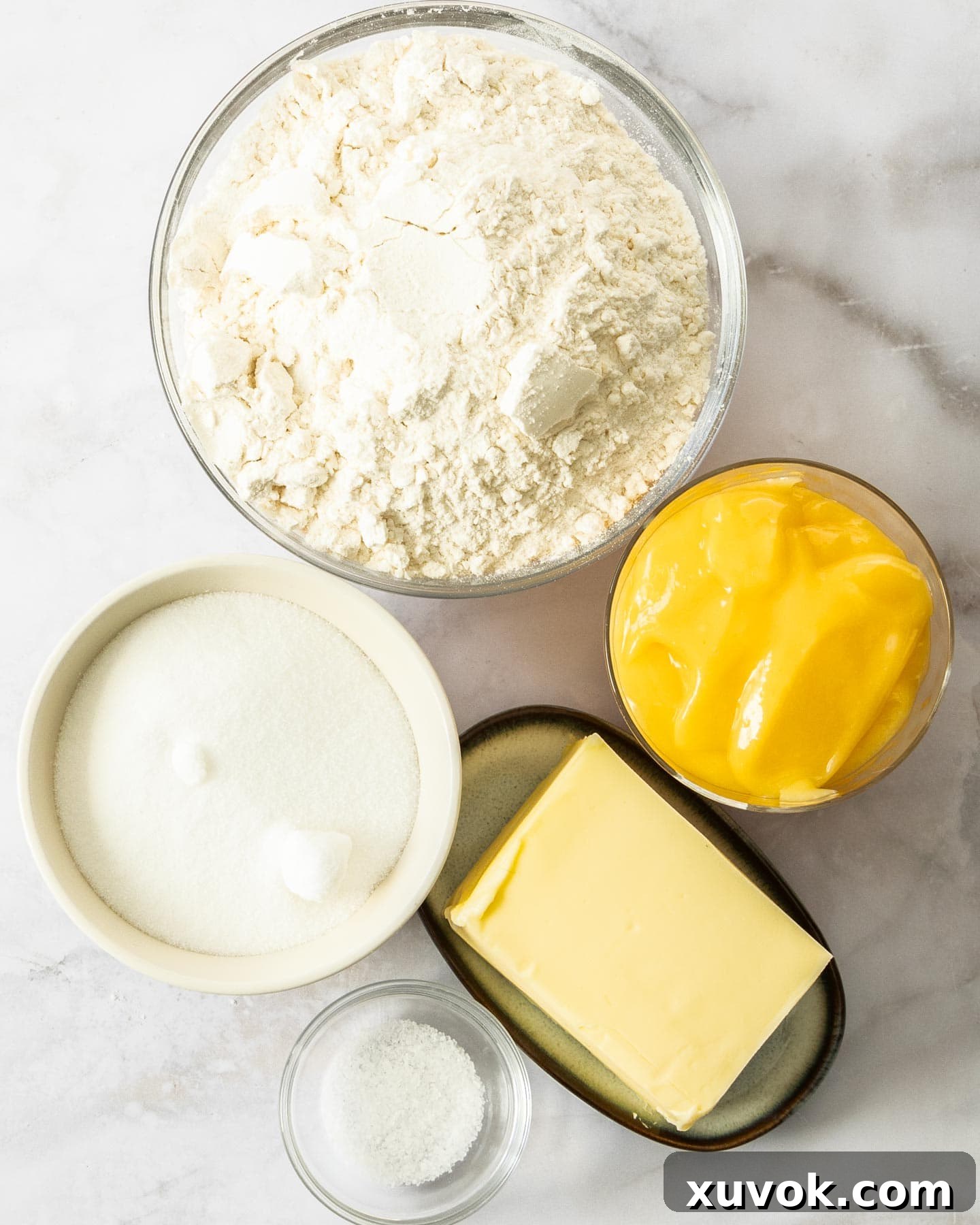 Ingredients for lemon curd bars on a marble surface.
