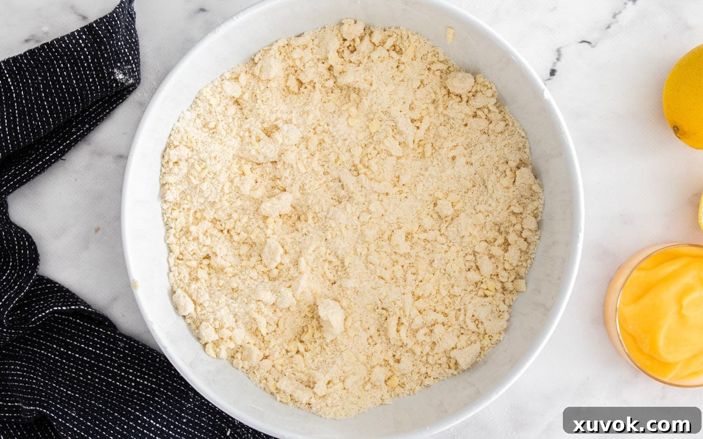 A bowl showing the flour and cold butter blended together.